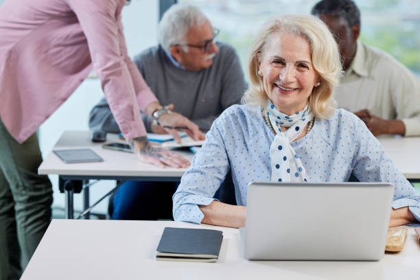 istock A senior woman is smiling while having a retraining class with a multicultural group of senior people in the classroom. 1392850093