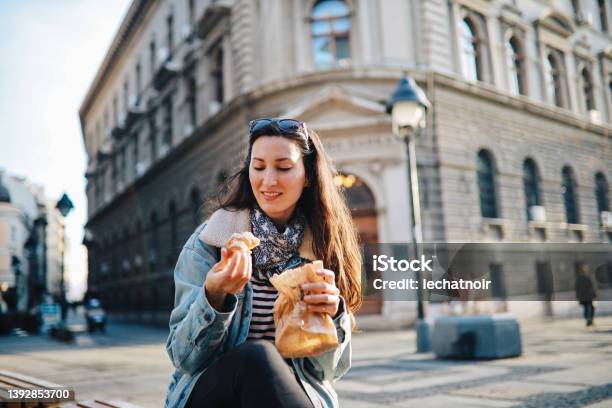 Young Woman Eating A Croissant On The Street Stock Photo - Download Image Now - Adult, Adults Only, Beautiful People