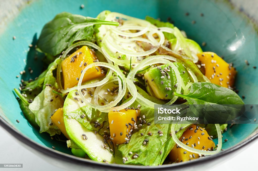 Fresh healthy food - green salad with avocado, mango. Vegetarian dish for restaurant on white background. Healthy organic vegan food. Healthy vegetarian lunch. Detox salad for diet. Eat less meat. Fresh healthy food - green salad with avocado, mango. Vegetarian dish for restaurant on white background. Healthy organic vegan food. Healthy vegetarian lunch. Detox salad for diet. Eat less meat Green Salad Stock Photo