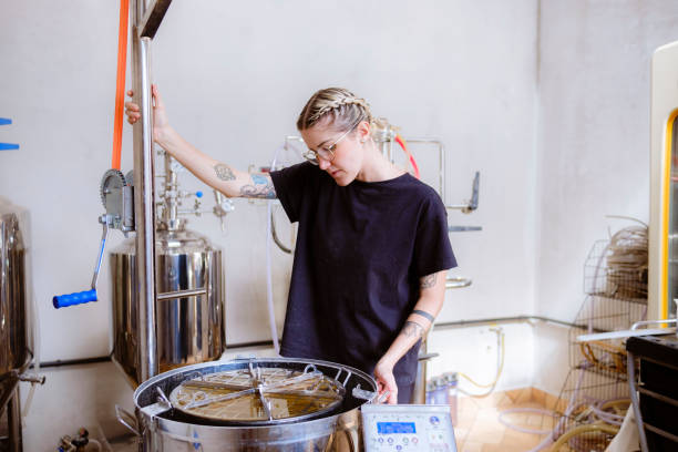 młoda kobieta wykonująca etap produkcji piwa rzemieślniczego. - brewery beer barley cereal plant zdjęcia i obrazy z banku zdjęć