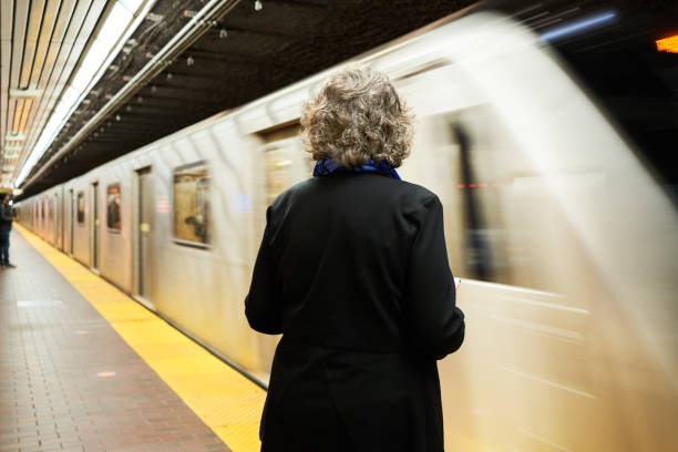 istock Mature woman waiting a subway platform for an arriving train 1392863610