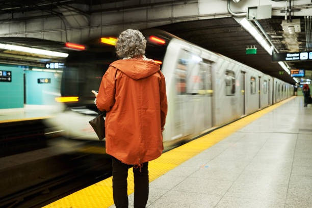 istock Mature woman waiting for a train a subway platform 1392863612