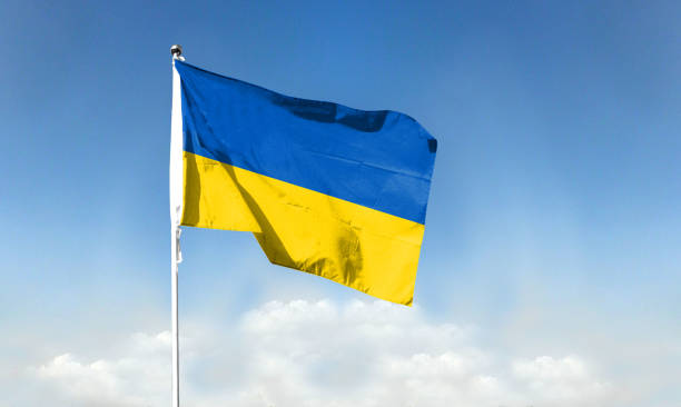 istock Ukrainian flag against blue sky. waving blue sky 1392866743
