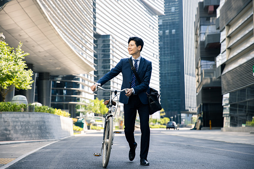 Businessman traveling through the city with his bicycle