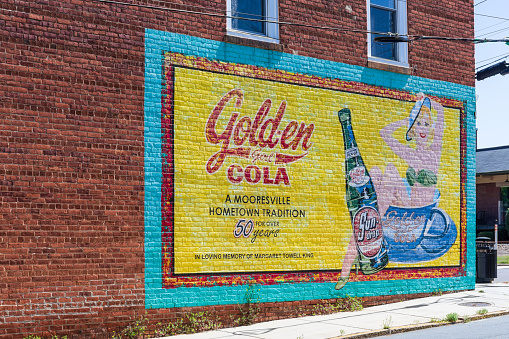 Mooresville, NC, USA-17 April 2022: An historic advertising painted sign for Sun-drop cola, Golden Girl Cola, 