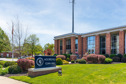 Mooresville, NC, USA-17 April 2022: Mooresville Town Hall, showing building and monument sign on a sunny spring day.