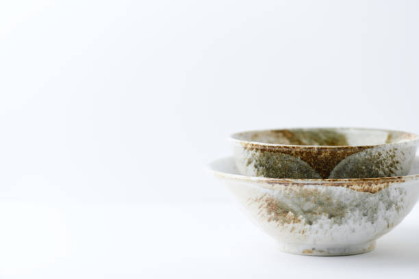 istock Traditional ceramic bowls on bright paper background. Soft focus. Close up. Copy space. 1392874092