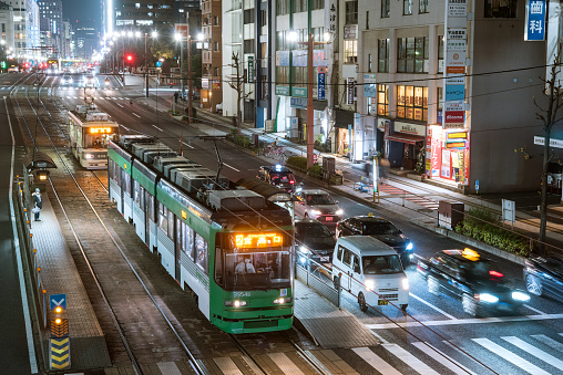 Hiroshima, Japan - November 19, 2021: Hiroshima Electric Railway streetcar stopping at Honkawacho Station near Peace Memorial Park at night.