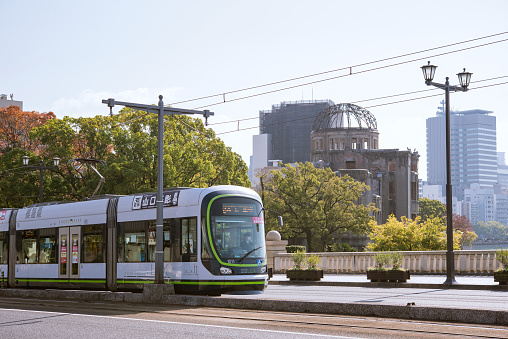 Hiroshima, Japan - November 20, 2021: Hiroshima Electric Railway streetcar and Atomic Bomb Dome.