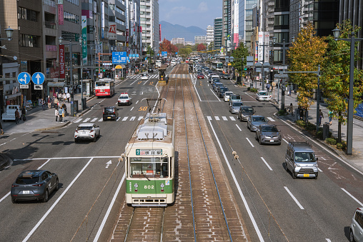 Hiroshima, Japan - November 20, 2021: Hiroshima Electric Railway streetcar running on Rijo Avenue in Hiroshima City.