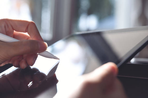 Woman using stylus pen on digital tablet computer, close up