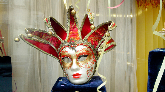 Venice, Italy - March 01, 2022: Woman dressed in traditional costume stand in front of the Bridge of Sighs, part of the Venice Mask Carnival, Veneto, Italy