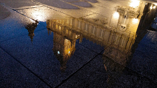 Puddle reflection of  A Coruña city Town hall, María Pita town square at dusk, Galicia, Spain.