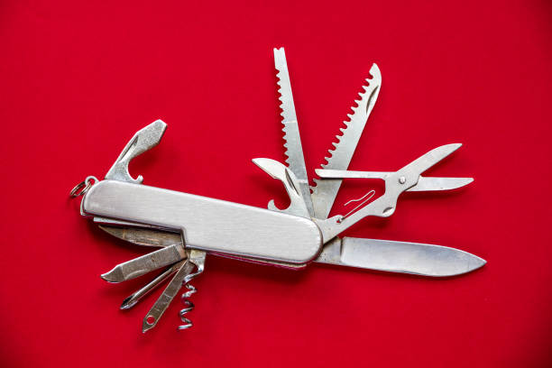 Metallic swiss knife isolated on red background