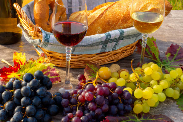 Symbol image of the grape harvest: Ripe grapes decorated with wine glasses on a wooden table stock photo