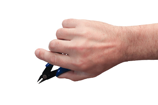 The instrument is in the right hand of a man on a white background. Isolate. Side cutters in a clenched palm with a protruding index finger.