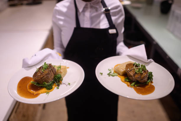 Waiter holding hot plated grilled steak and vegetables
