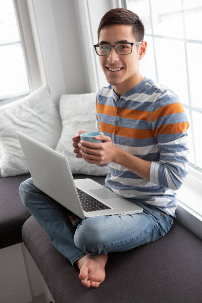 istock Young adult using laptop at home 1392893132