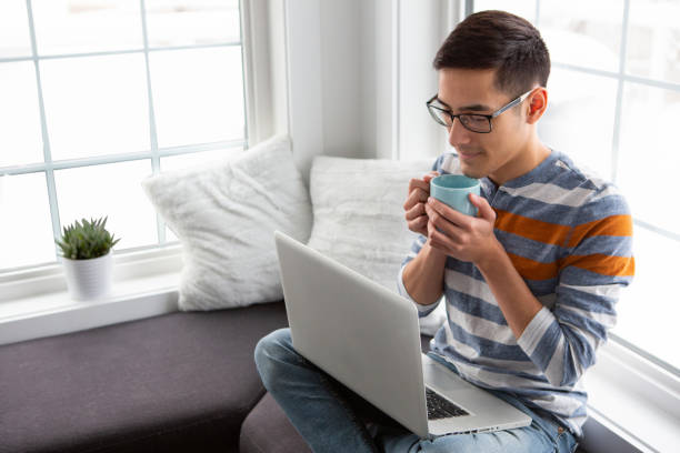 istock Young adult using laptop at home 1392893532