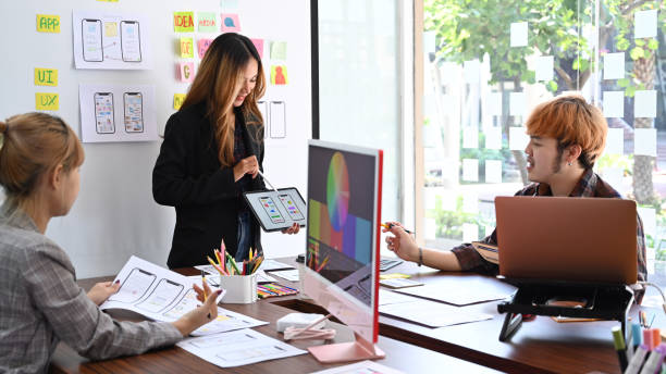 istock Group of professionals web developers brainstorming and working together for mobile application software design project. 1392894757