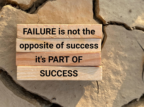 Inspirational motivational quote. Failure is not the opposite of success, it's part of success. Text on wooden blocks background.