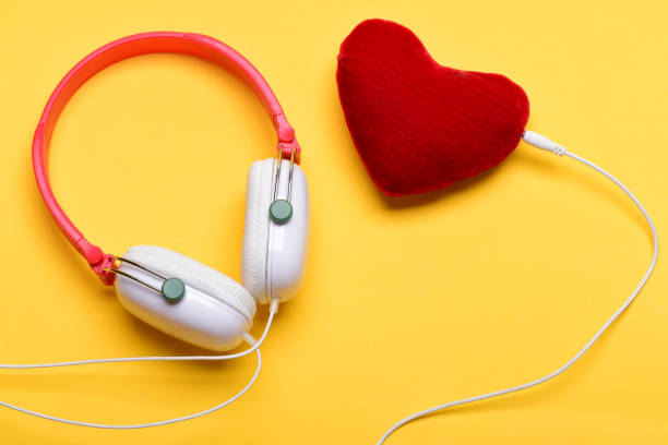 kopfhörer in weißer und roter farbe mit plüschtierherz - internet dating audio stock-fotos und bilder