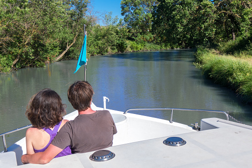 Romantic vacation, holiday travel on barge boat in canal, happy couple having fun on river cruise in houseboat