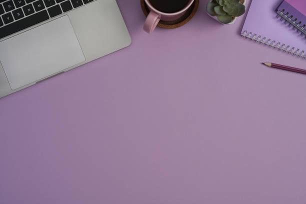istock Top view computer laptop, notebook, succulent plants and coffee cup on purple background with copy space. 1392897710