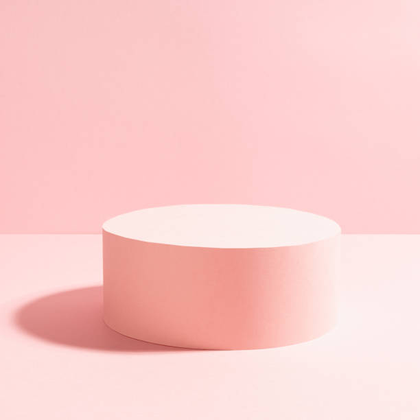 istock Romantic pastel pink stage with one round podium in bright sunlight with shadow on gentle shine soft light background, square.  Mockup for presentation cosmetic product, goods, advertising, show. 1392904339