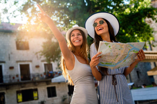 Happy group of young women friends enjoying sightseeing tour in the city on summer vacation. stock photo