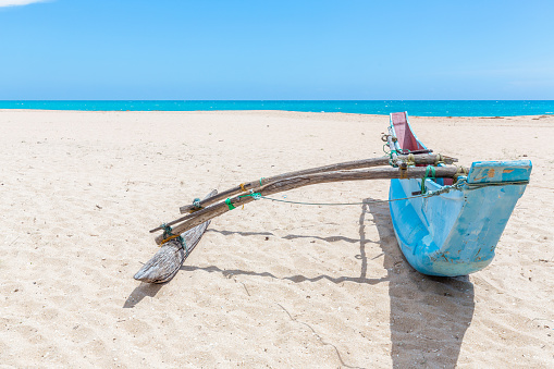 Traditional Sri Lankan fishing boat stranded on the beach in Rekawa