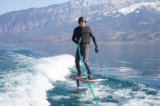 istock View of man riding wake foil behind motor boat 1392909896