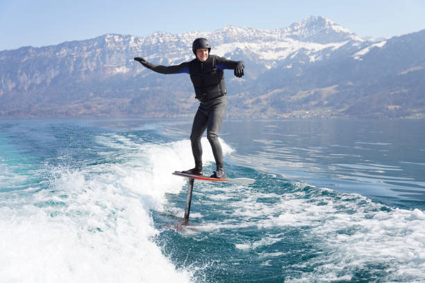istock View of man riding wake foil behind motor boat 1392910093