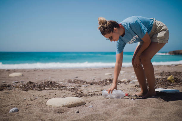 istock A volunteer cleans garbage from the beach. 1392911356