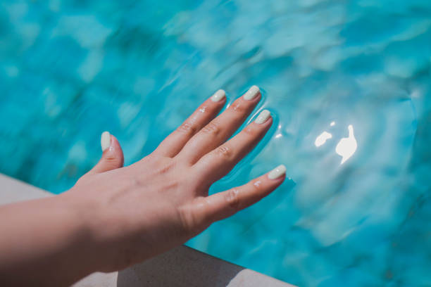 istock A woman's hand touches the water surface of the pool. 1392911357