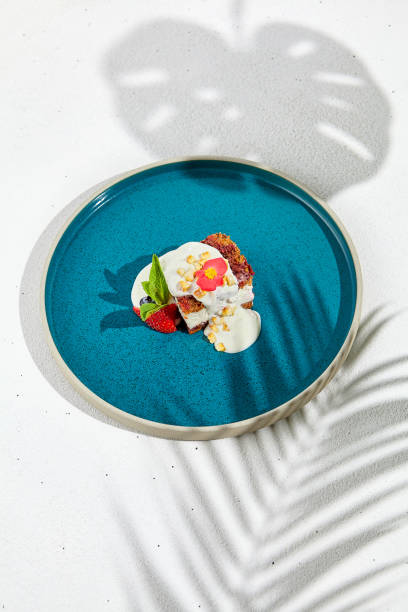 istock Carrot cake with cream cheese and berries on ceramic plate. Elegant dessert - carrot pie on white background with shadows of leaves. Portion cake on modern plate in minimal style. 1392914089