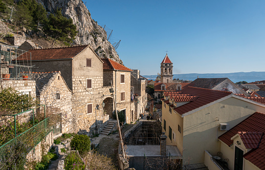 Street view and bell tower of St Michael's church in the old town of Omis, Croatia