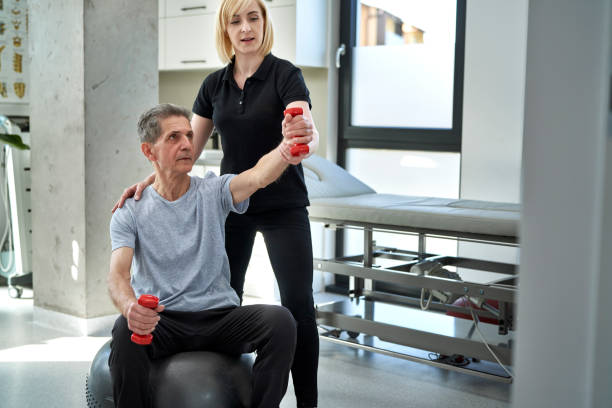 istock Female physical therapist working with senior man 1392915249