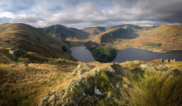 istock Dramatic light shining across a rugged landscape in the Lake District, with moody clouds 1392915259