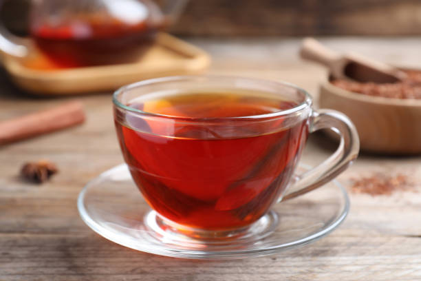 istock Freshly brewed rooibos tea on wooden table, closeup 1392917121