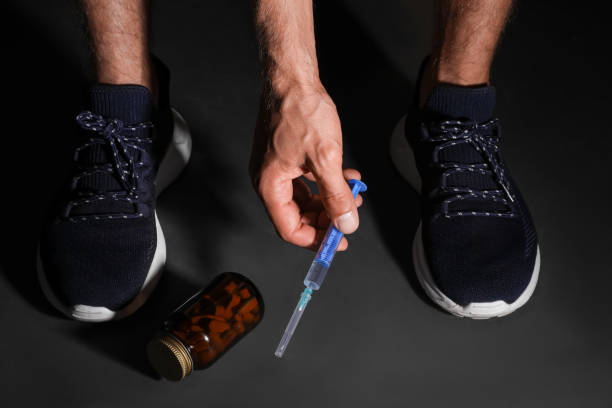 man taking syringe from black floor, closeup. doping concept - steroids imagens e fotografias de stock