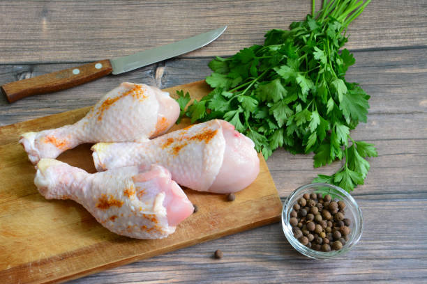 istock raw chicken legs on cutting board with spices, close-up 1392920107