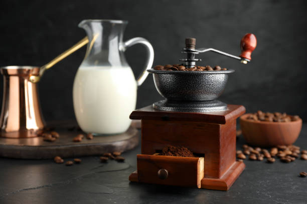 istock Vintage manual coffee grinder with beans and powder on black table 1392920114