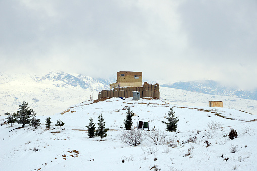 Takht-e Rustam, Haibak / Aybak / Samangan, Samangan Province, Afghanistan: hill top fort from the civil war period, built on the foothills of the Hindu Kush mountains, controlling the road  - winter view with snow.