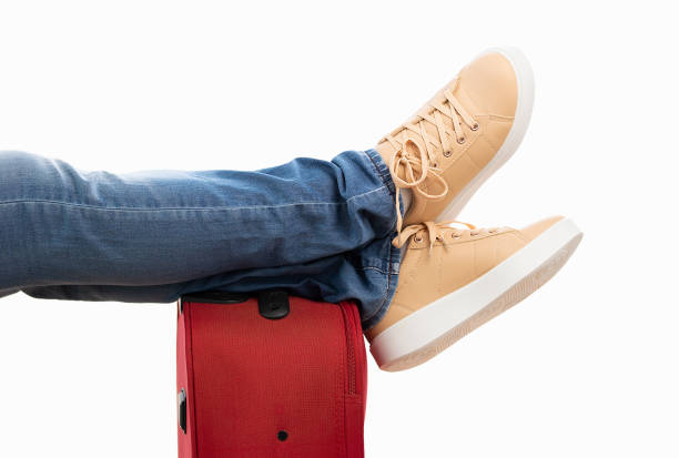 Detail of person resting with legs over the baggage with white background