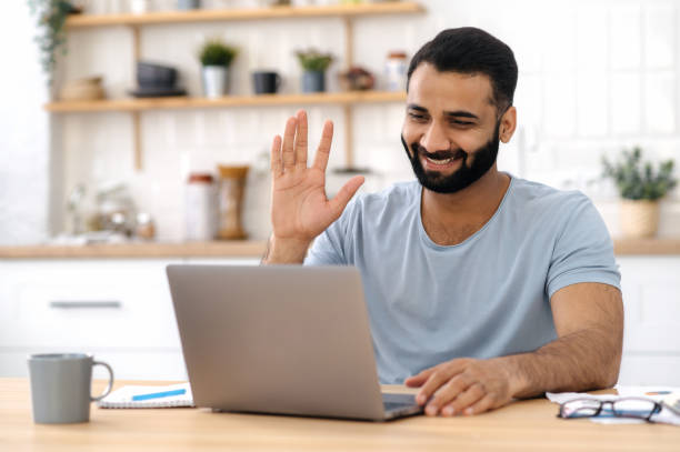 istock Video conference, distant communication. Positive Indian man, freelancer, designer or manager, work from home, using a laptop for communication via video call, talking to a colleague or friend, smiles 1392923424