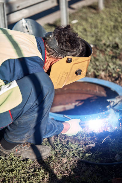 istock Welder handyman working on a sewer manhole lid. 1392923505