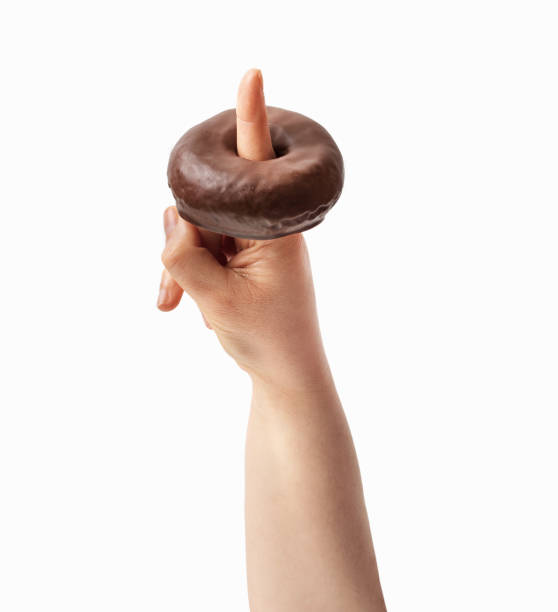 istock woman holding a chocolate donut 1392923528