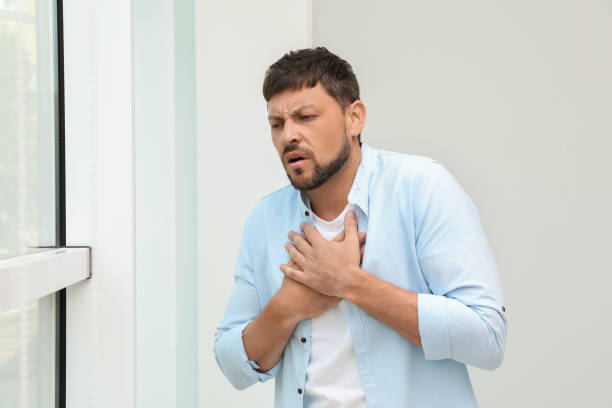 istock Man suffering from pain during breathing near window 1392923646