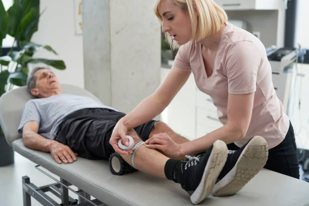 istock Female physical therapist measuring senior's man leg 1392924162
